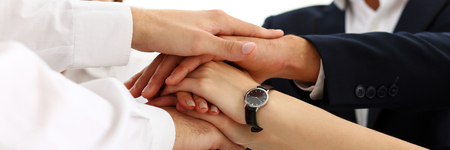 Group of people in suits crossed hands in pile for win closeup. White collar leadership, high five, cooperation initiative achievement, corporate life style, friendship deal, heap, stack conceptの写真素材