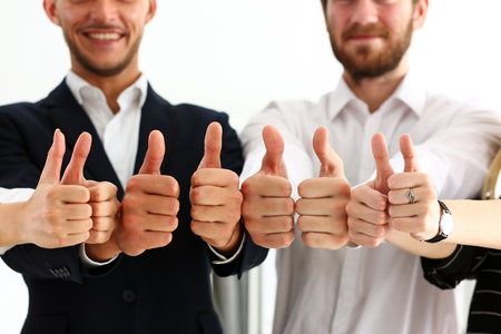 Group of people show OK or confirm with thumb up during conference closeup. High level quality product, serious offer, excellent education, mediation solution, creative advisor participation conceptの写真素材