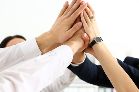 Group of people in suits crossed hands in pile for win closeup. White collar leadership, high five, cooperation initiative achievement, corporate life style, friendship deal, heap, stack conceptの写真素材