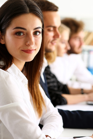 Beautiful smiling woman portrait with group of people listen carefully during seminar. Study event, client conversation, job, customer support service, case hear in court, leader performance conceptの写真素材