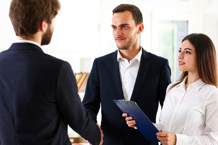 Smiling man in suit shake hands as hello in office portrait. Friend welcome, mediation offer, positive introduction, greet or thanks gesture, summit participate approval, strike arm bargain conceptの写真素材