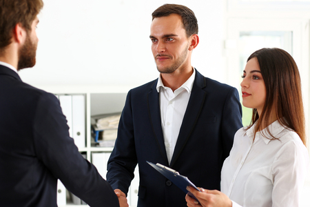 Smiling man in suit shake hands as hello in office portrait. Friend welcome, mediation offer, positive introduction, greet or thanks gesture, summit participate approval, strike arm bargain conceptの写真素材