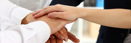 Group of people in suits crossed hands in pile for win closeup. White collar leadership, high five, cooperation initiative achievement, corporate life style, friendship deal, heap, stack conceptの写真素材