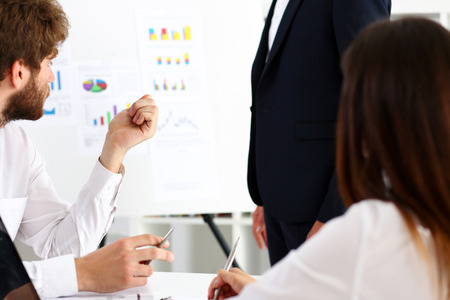 Group of people deliberate on white board problem in office closeup. Graph consult, idea participate, creative talk, review situation job, document explain council, train, successful decision conceptの写真素材