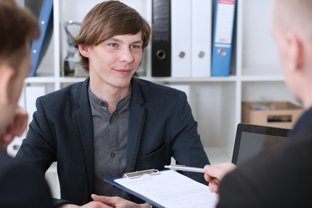 Group of people deliberate on problem with clipboard pad closeup. White collar check money papers, stock exchange market, earnings list, partnership agreement idea discussion, startup conceptの写真素材