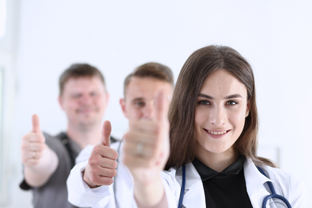 Group of doctor show OK or approval sign with thumb up portrait. High level service, best treatment, 911, healthy lifestyle, satisfied patient, therapeutist consultation, physical conceptの写真素材