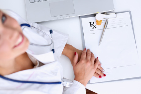 Female doctor hand hold jar of pills and write prescription at worktable. Panacea and life save, prescribe antidepressant, legal drug store, ward round, give or take potion, vitamin aid conceptのeditorial素材