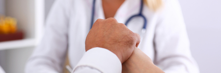 Young couple hold arms together in family doctor office closeup. Motherhood and child delivery IVF, new life, abortion, therapeutist reception service, physical, hope emotion, hospital expectationの写真素材