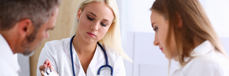 Female family doctor listen carefully young couple in office. Motherhood and child delivery IVF, new life, abortion, therapeutist reception service, physical, hope emotion, hospital expectationのeditorial素材