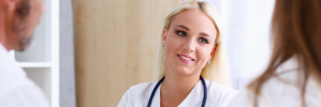 Female family doctor listen carefully young couple in office. Motherhood and child delivery IVF, new life, abortion, therapeutist reception service, physical, hope emotion, hospital expectationのeditorial素材