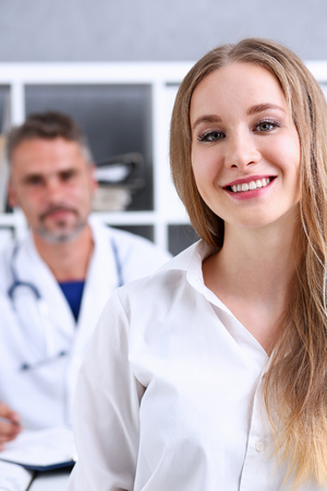 Satisfied happy beautiful smiling female with doctor at his office. High level and quality medical service, therapeutist consultation appointment, work and career, physical, healthy lifestyle conceptのeditorial素材