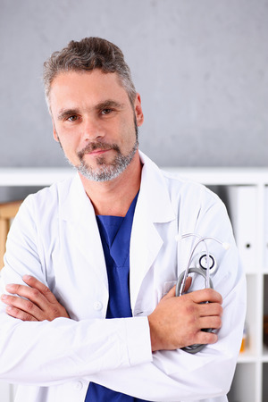 Handsome mature smiling male doctor with arms crossed on chest portrait. Medic store, physical and patient disease prevention, er consultant, 911, profession, pulse measure, healthy lifestyle conceptのeditorial素材