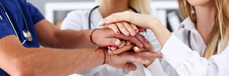 Group of doctor crossed arms in pile for win closeup. High five, cooperation initiative achievement, heap, stack, people cure strategy, colleague competition, heal alliance, hospital visit conceptの写真素材