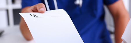 Male medicine doctor hand hold and give prescription form to patient closeup. Panacea, life save, prescribe treatment, legal drug store, contraception concept. Empty form ready to be usedの写真素材