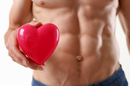 Athletic man holds a heart in his handの写真素材