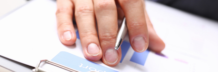 Hand of businessman in suit filling and signing with silver pen partnership agreement form clipped to pad closeup. Management training course, some important document, team leader ambition conceptの写真素材