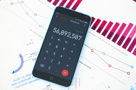 Smartphone calculator and financial statistics ondisplay tablet at office table closeup. Internal Revenue Service inspector sum check, irs investigation, earnings, savings, loan and credit conceptの写真素材