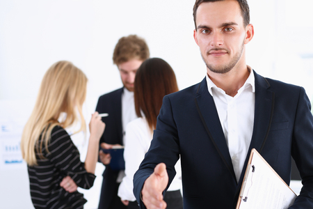 Smiling handsome cheerful man offer hand as hello in office portrait. Serious excellent prospect, friendly support service, introduction or thanks gesture, gratitude, invite to participate conceptの写真素材