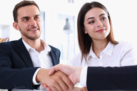Smiling man in suit shake hands as hello in office portrait. Friend welcome, mediation offer, positive introduction, greet or thanks gesture, summit participate approval, strike arm bargain conceptの写真素材