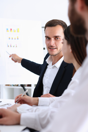 Group of people deliberate on white board problem in office portrait. Graph consult, idea participate, creative talk, review situation job, document explain, train, successful decision conceptの写真素材