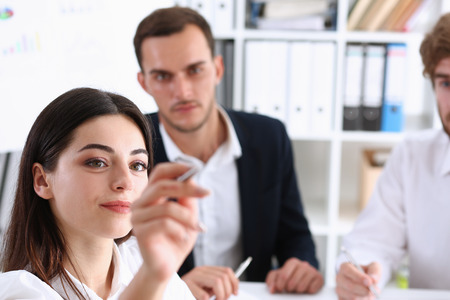 eautiful blonde woman make some marks on screen or glass wall with silver pen. Fresh view, discuss problem, review situation, look at new angle, professional training, memo graph or chart conceptの写真素材