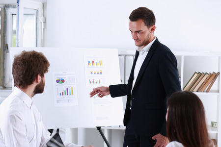 Group of people deliberate on white board problem in office closeup. Graph consult, idea participate, creative talk, review situation job, document explain council, train, successful decision conceptの写真素材