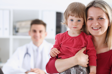 Little child with mother at pediatrician reception. Physical exam, cute infant portrait, baby aid, healthy lifestyle, ward round, child sickness, clinic test, high quality and trust conceptの写真素材