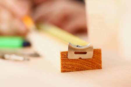 Arms of worker measuring wooden bar closeup. Manual job, DIY inspiration, improvement job, fix shop, yellow helmet, joinery startup, workplace idea, designer career, ruler, industrial educationの写真素材