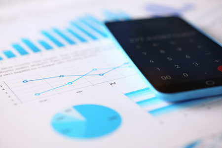 Smartphone calculator and financial statistics ondisplay tablet at office table closeup. Internal Revenue Service inspector sum check, irs investigation, earnings, savings, loan and credit concept