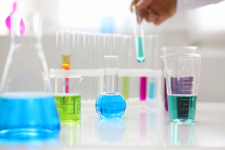 Chemical industry bulb with blue magenta pink liquid lab tubes stand on the table in the laboratory of liquid testing test development substances poisons additives stabilizers flavors house cleaningの写真素材