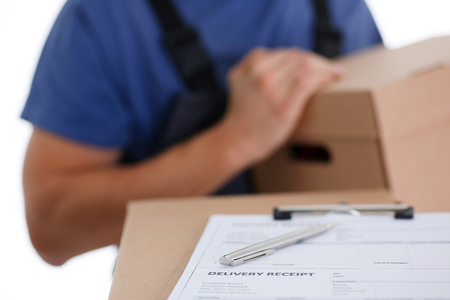 Specialist courier delivery service offers to fill the contract of cooperation to the client. Terms of delivery are agreed upon and signed by both parties with a pen in handの写真素材