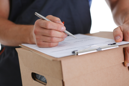 Specialist courier delivery service offers to fill the contract of cooperation to the client. Terms of delivery are agreed upon and signed by both parties with a pen in handの写真素材