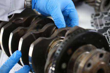 The mechanic of the service center for engine repair considers problem crankshaft on which as a...