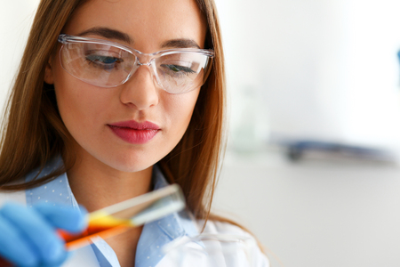 Technician hold in arms in protective gloves sample bottleの写真素材