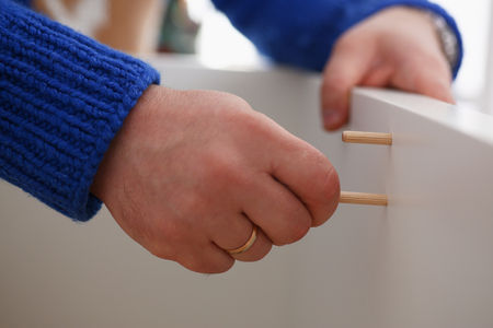 Male arms assembling furniture closeupの写真素材