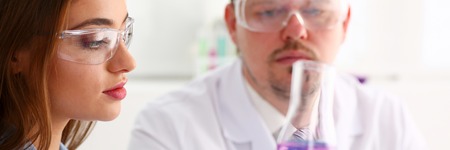 Technician hold in arms in protective gloves sample bottle
