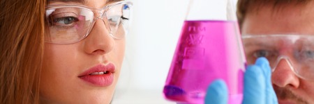 Technician hold in arms in protective gloves sample bottleの写真素材