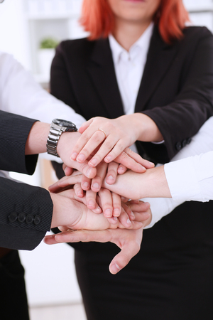 Group of people in suits crossed hands pileの写真素材