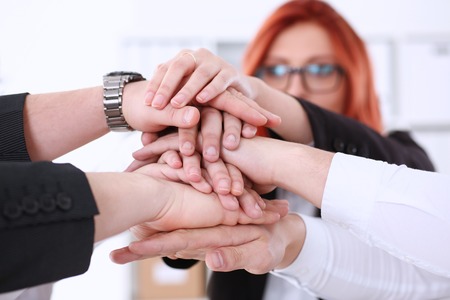 Group of people in suits crossed hands pileの写真素材