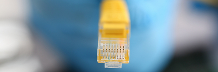 male hand in blue protective gloves holds a network connectorの写真素材