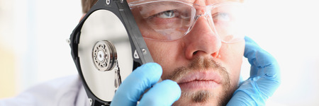 Repairman attached the hard drive of the computer to his earの写真素材