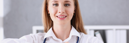 Beautiful smiling doctor hold in arms red heartの写真素材