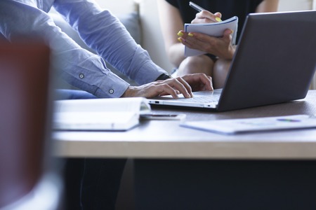 Two business people are comparing information