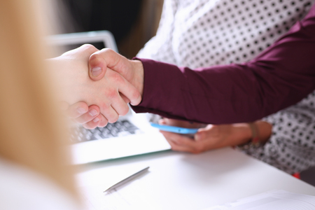 Man in suit shake hand as hello in officeの写真素材