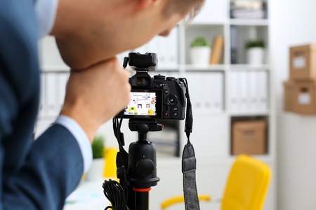 Male arms in suit mount camcorder to tripodの写真素材