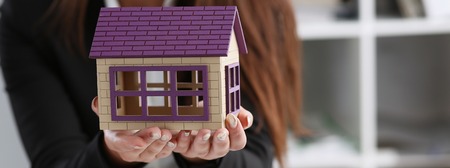 Businesswoman in the office holds a miniatureの写真素材