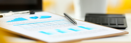 Silver pen lying on important stats paper clipped to padの写真素材