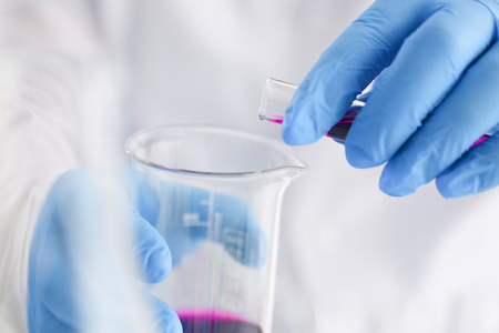 A male chemist holds test tube of glassの写真素材