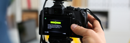 Male arms in suit mount camcorder to tripodの写真素材