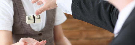 Businessman hands a cutlet out of moneyの写真素材